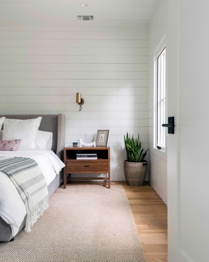 Idee per una camera matrimoniale country con pareti bianche, parquet chiaro e pavimento beige