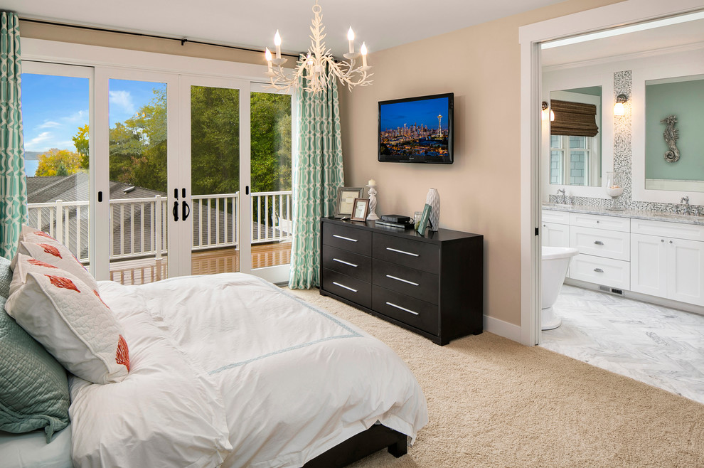 Modelo de dormitorio principal costero de tamaño medio con paredes beige y moqueta