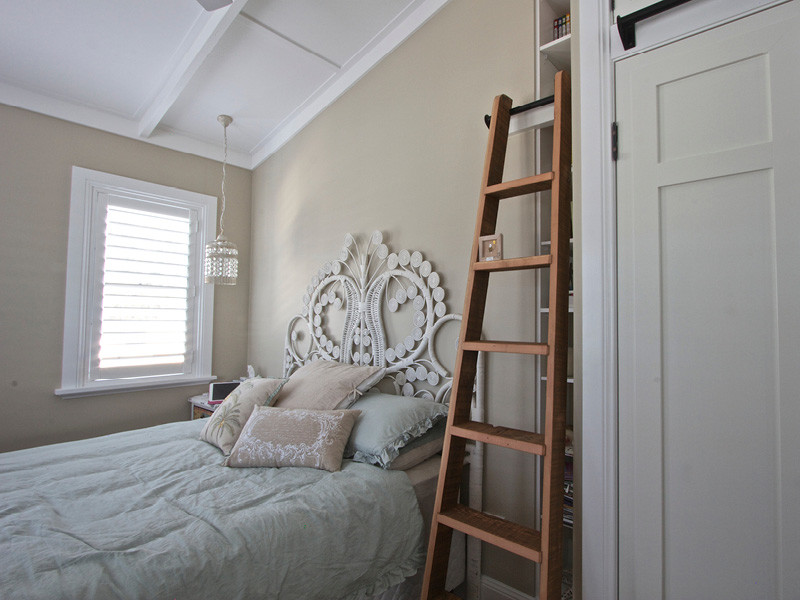 Esempio di una camera da letto country con pareti beige e pavimento in legno massello medio