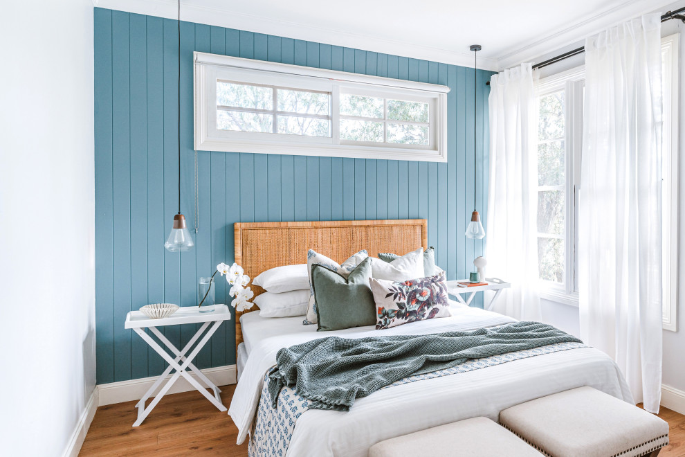 Идея дизайна: гостевая спальня (комната для гостей) в морском стиле с синими стенами, светлым паркетным полом, коричневым полом и панелями на части стены без камина