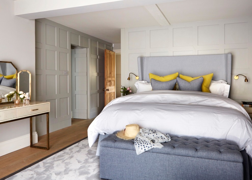 Ispirazione per una camera da letto classica di medie dimensioni con pareti beige, pavimento in legno massello medio e pavimento marrone