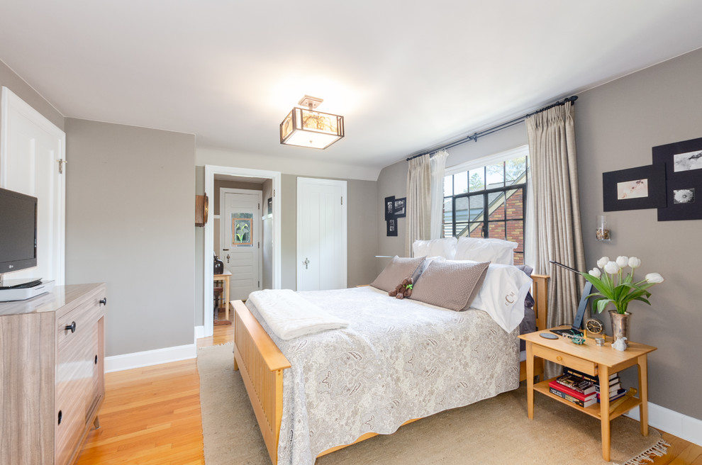 Immagine di una camera da letto classica con pareti grigie, pavimento in legno massello medio e pavimento marrone