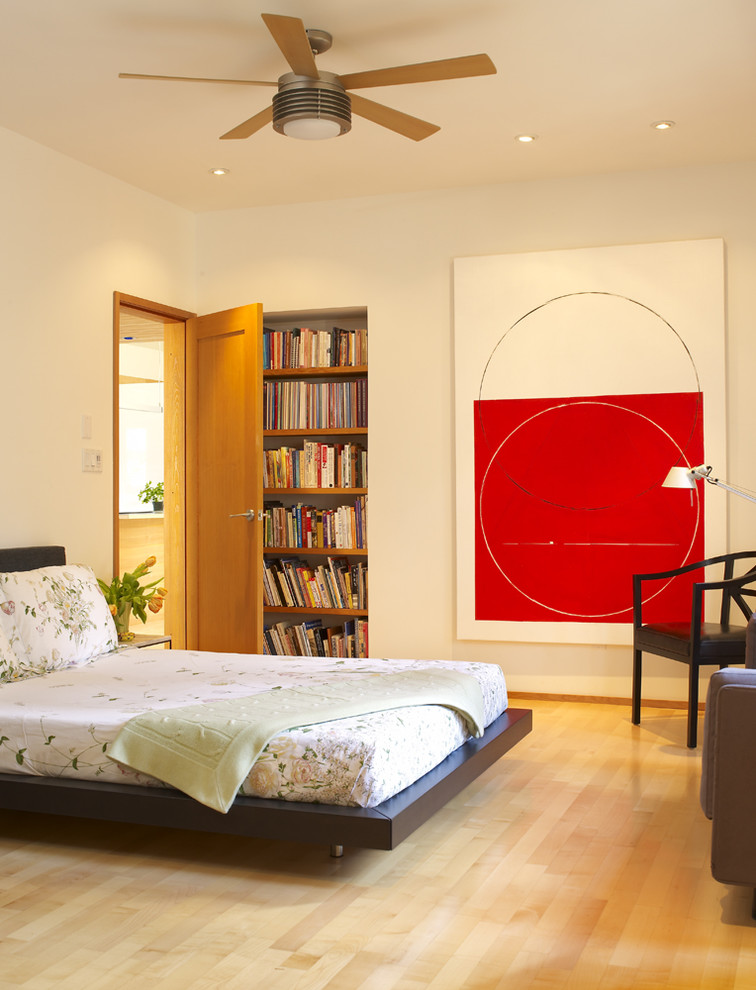 Inspiration for a modern medium tone wood floor bedroom remodel in Vancouver with beige walls