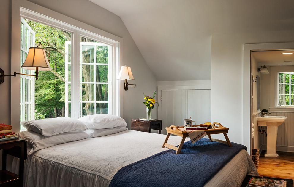 Diseño de dormitorio clásico sin chimenea con paredes blancas y suelo de madera en tonos medios