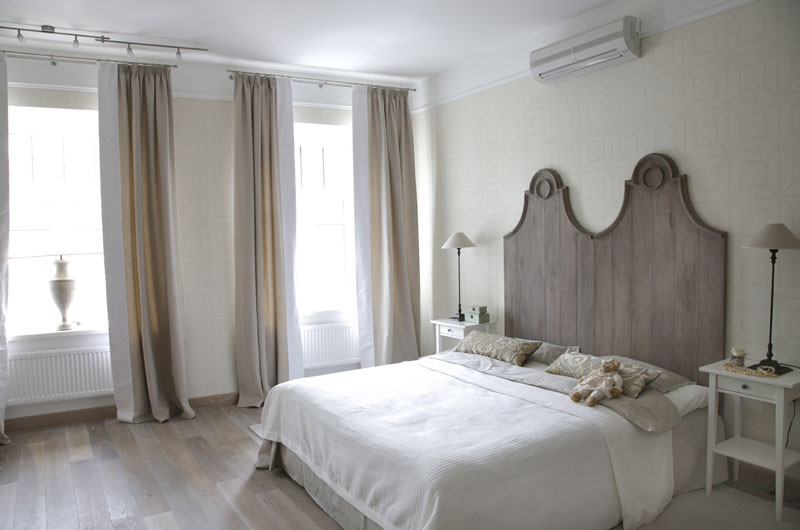 Foto de dormitorio principal clásico renovado grande sin chimenea con paredes beige y suelo de madera clara