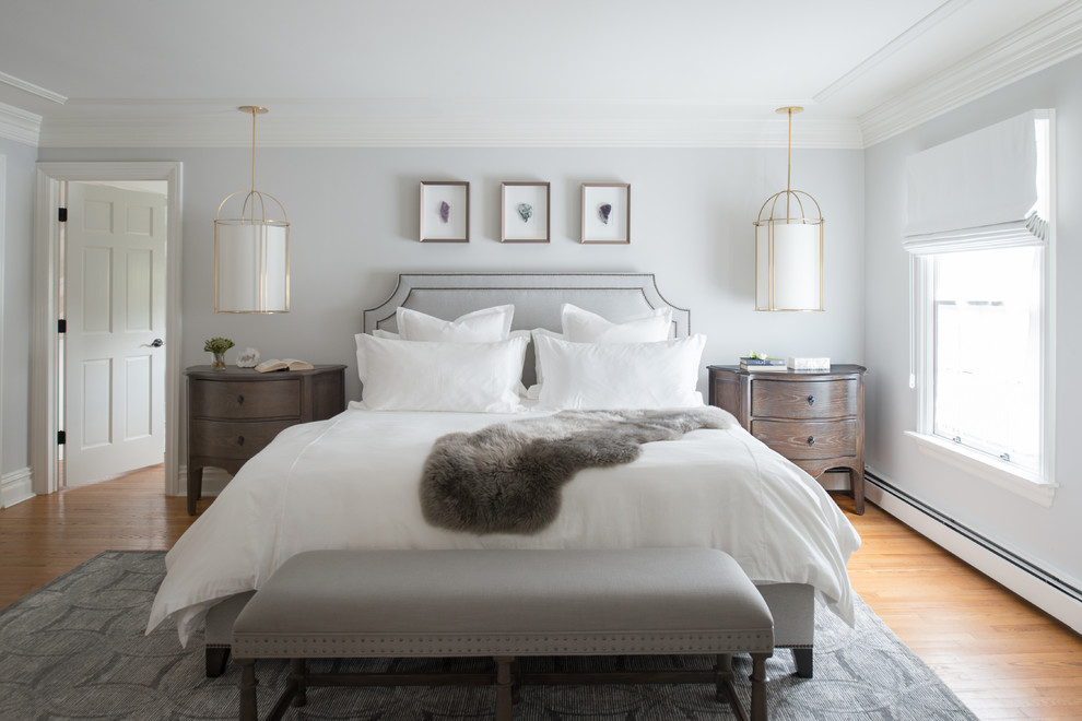 Idée de décoration pour une grande chambre parentale tradition avec un mur gris, un sol en bois brun et un sol marron.