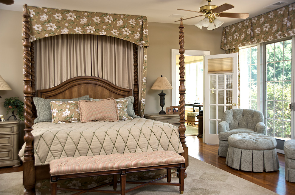 Modelo de dormitorio principal tradicional grande sin chimenea con paredes beige, suelo de madera en tonos medios y suelo marrón