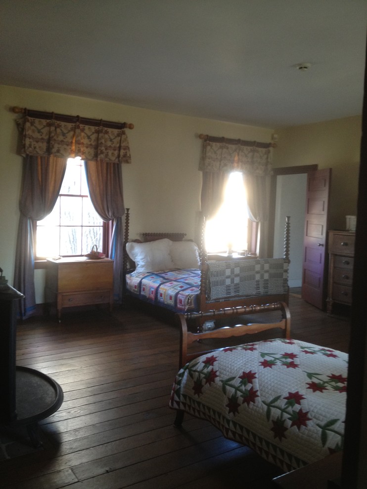 Imagen de dormitorio de estilo de casa de campo grande con suelo de madera en tonos medios, todas las chimeneas y marco de chimenea de madera