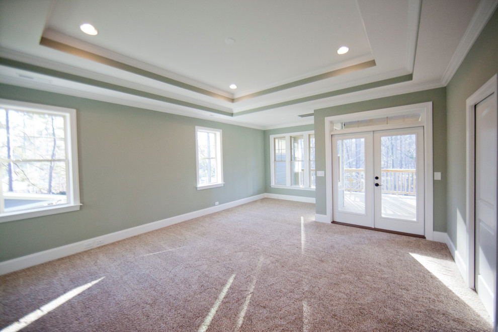 This is an example of a large bedroom in Raleigh with carpet.