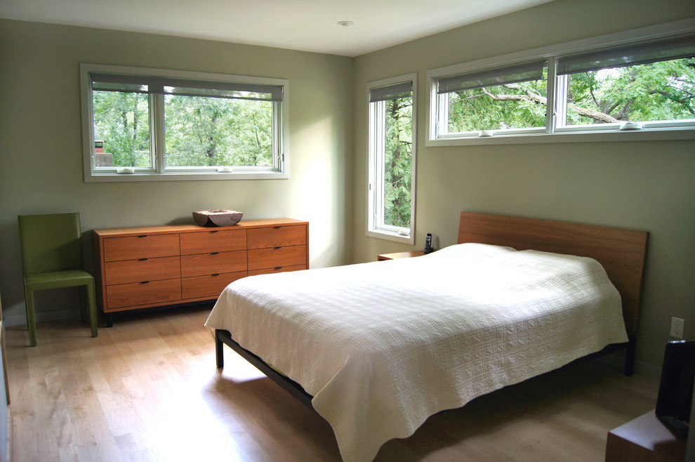 Imagen de dormitorio principal retro con paredes verdes y suelo de madera clara