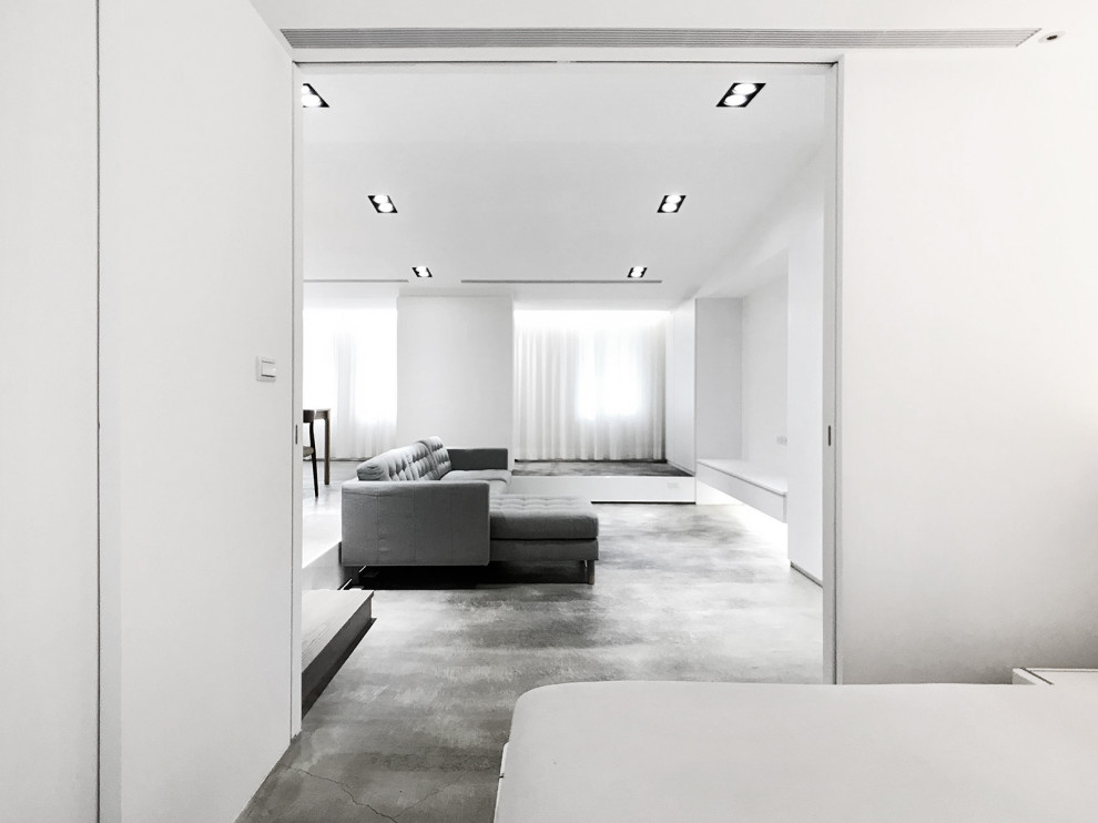 Idéer för funkis sovrum, med vita väggar, betonggolv och grått golv