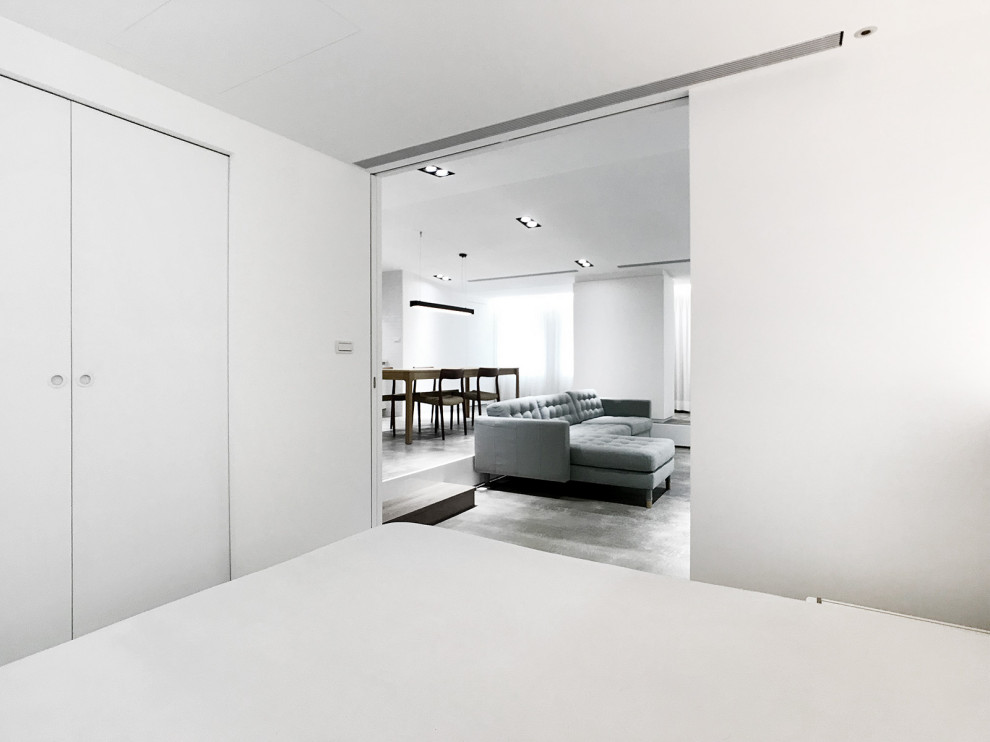 Modernes Schlafzimmer mit weißer Wandfarbe, Betonboden, grauem Boden und gewölbter Decke in Berlin