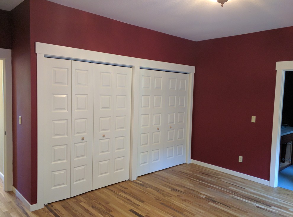 Idee per una camera matrimoniale american style di medie dimensioni con pareti rosse, pavimento in legno massello medio e nessun camino