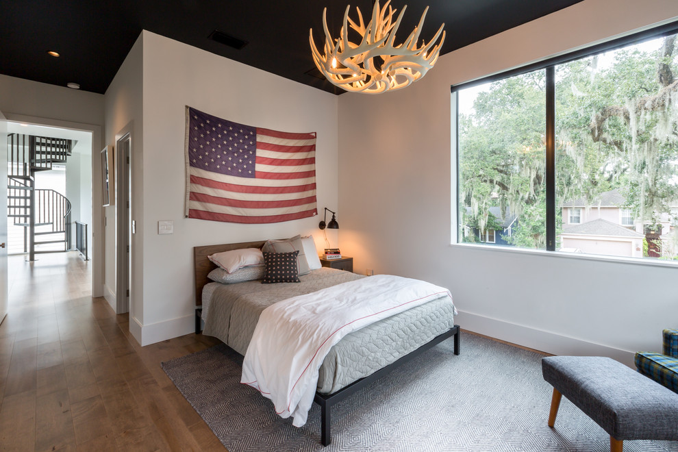 Imagen de habitación de invitados minimalista de tamaño medio con paredes blancas y suelo de madera en tonos medios