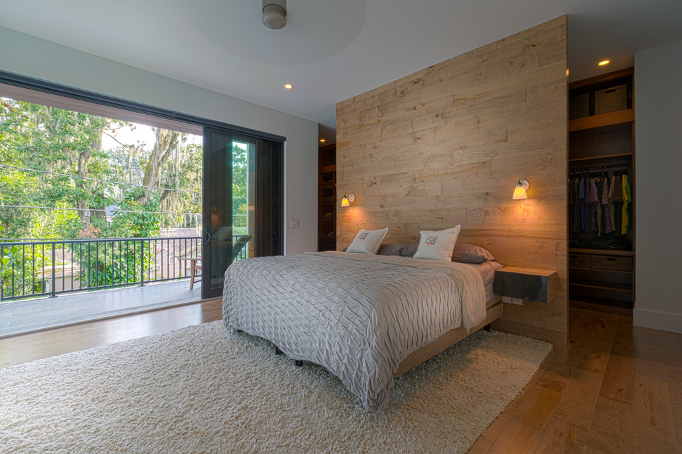 Diseño de dormitorio principal minimalista de tamaño medio con paredes blancas y suelo de madera en tonos medios