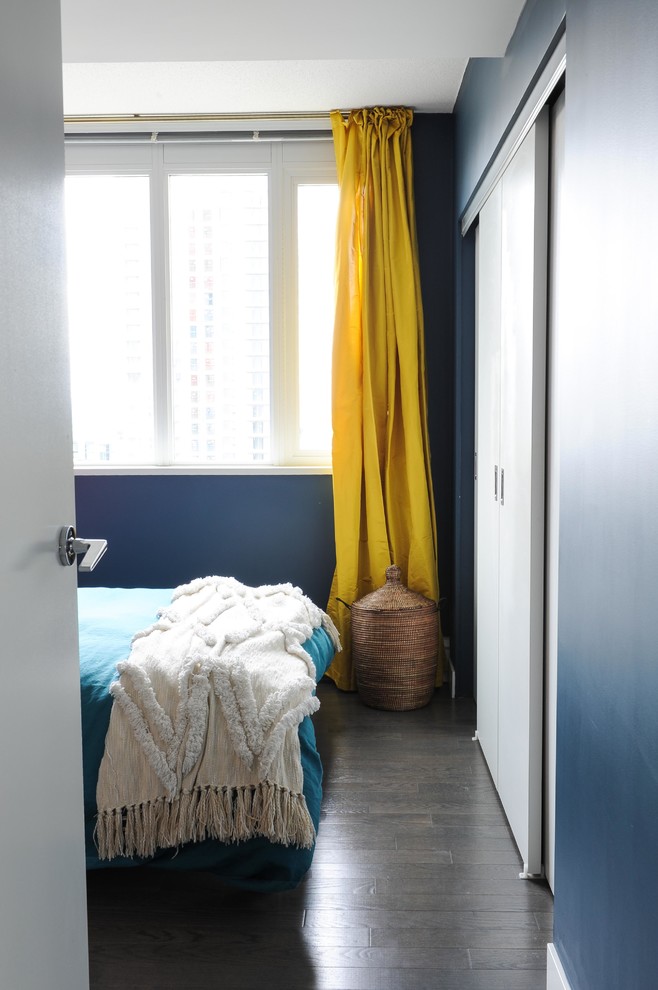 Cette image montre une chambre parentale bohème avec un mur bleu, parquet foncé et un sol marron.
