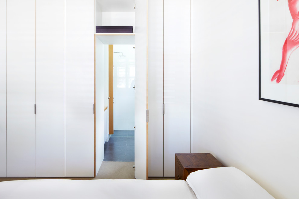 На фото: хозяйская спальня среднего размера в стиле модернизм с белыми стенами и ковровым покрытием