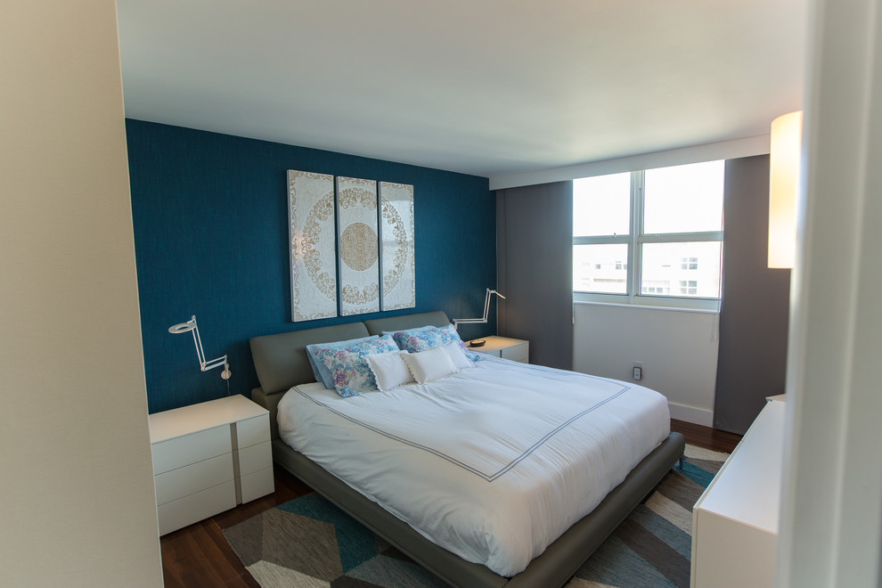 Exemple d'une chambre parentale tendance de taille moyenne avec un mur bleu, parquet foncé, aucune cheminée et un sol marron.