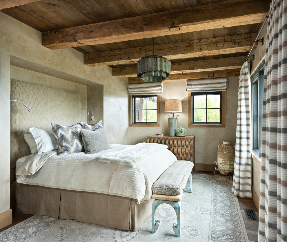 Großes Uriges Hauptschlafzimmer mit beiger Wandfarbe, braunem Boden und dunklem Holzboden in Sonstige