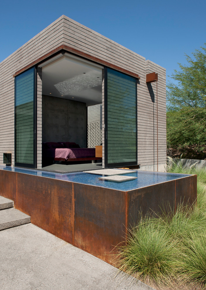 Стильный дизайн: хозяйская спальня в стиле модернизм с серыми стенами и бетонным полом - последний тренд