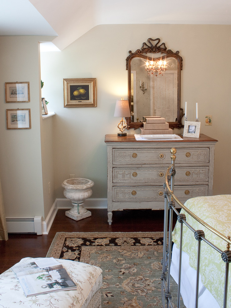 This is an example of a traditional bedroom in Boston with beige walls and dark hardwood flooring.