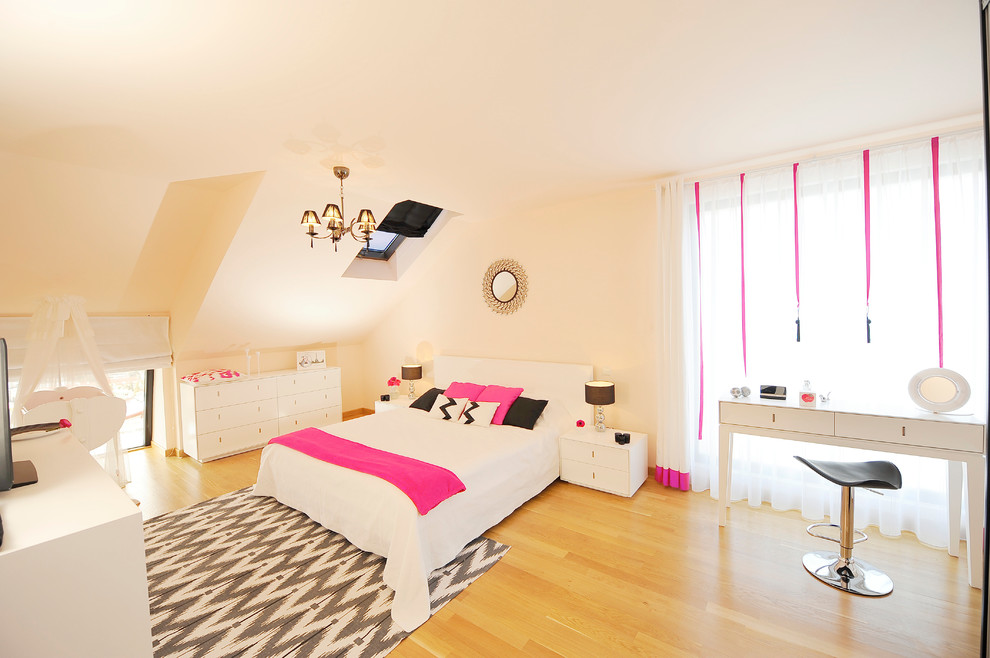 Modelo de dormitorio contemporáneo con paredes beige y suelo de madera en tonos medios