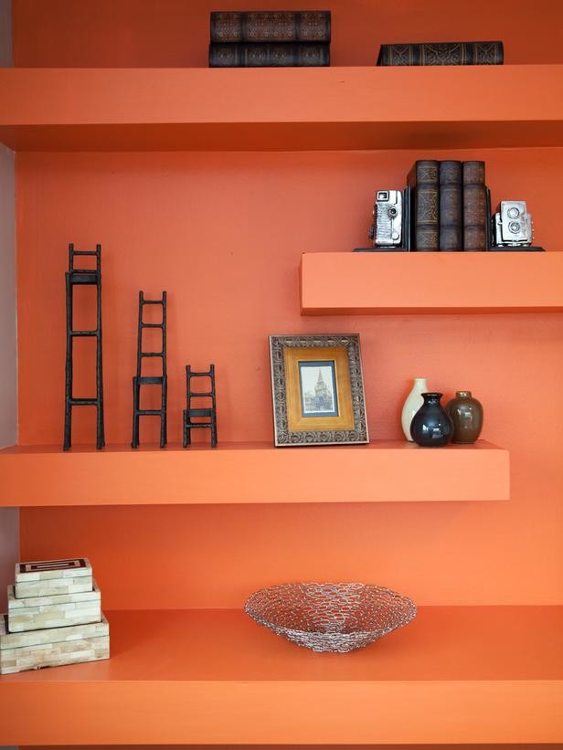 Imagen de habitación de invitados minimalista pequeña sin chimenea con parades naranjas y suelo de madera oscura