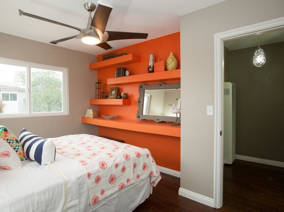 Modelo de habitación de invitados bohemia pequeña sin chimenea con parades naranjas y suelo de madera oscura