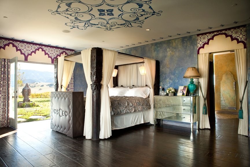 Diseño de dormitorio principal exótico grande con paredes azules y suelo de madera oscura