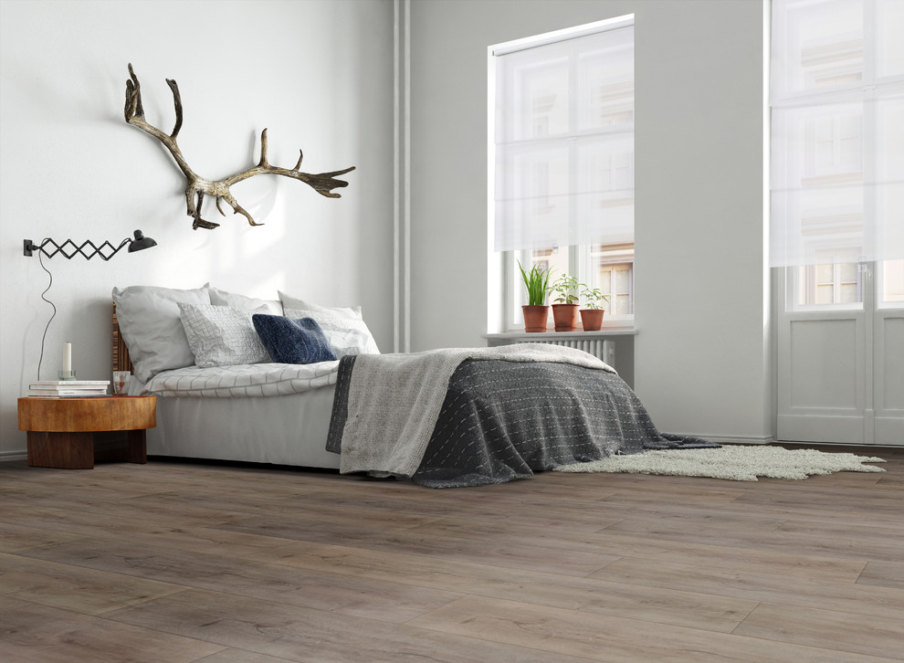 Imagen de habitación de invitados actual de tamaño medio sin chimenea con paredes blancas, suelo de madera clara y suelo gris