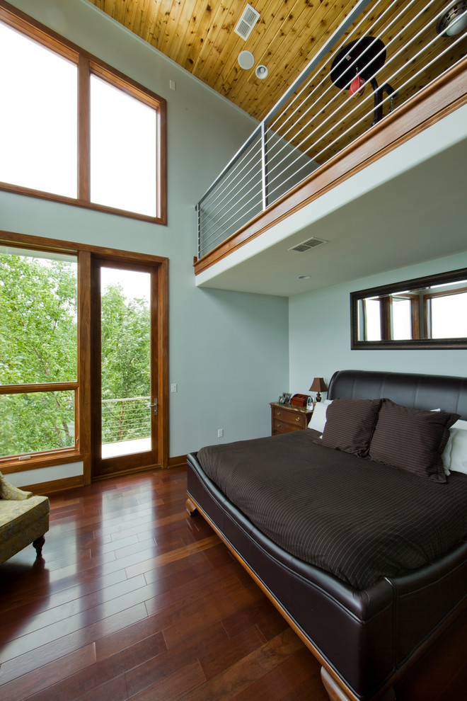 Diseño de dormitorio actual con paredes grises y suelo de madera oscura