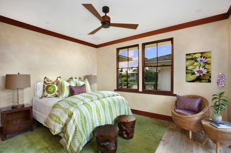 Esempio di una grande camera degli ospiti tropicale con pareti beige e parquet chiaro