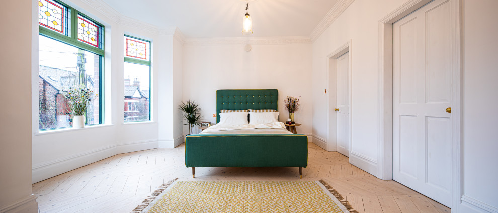 マンチェスターにあるヴィクトリアン調のおしゃれな主寝室 (白い壁、淡色無垢フローリング)