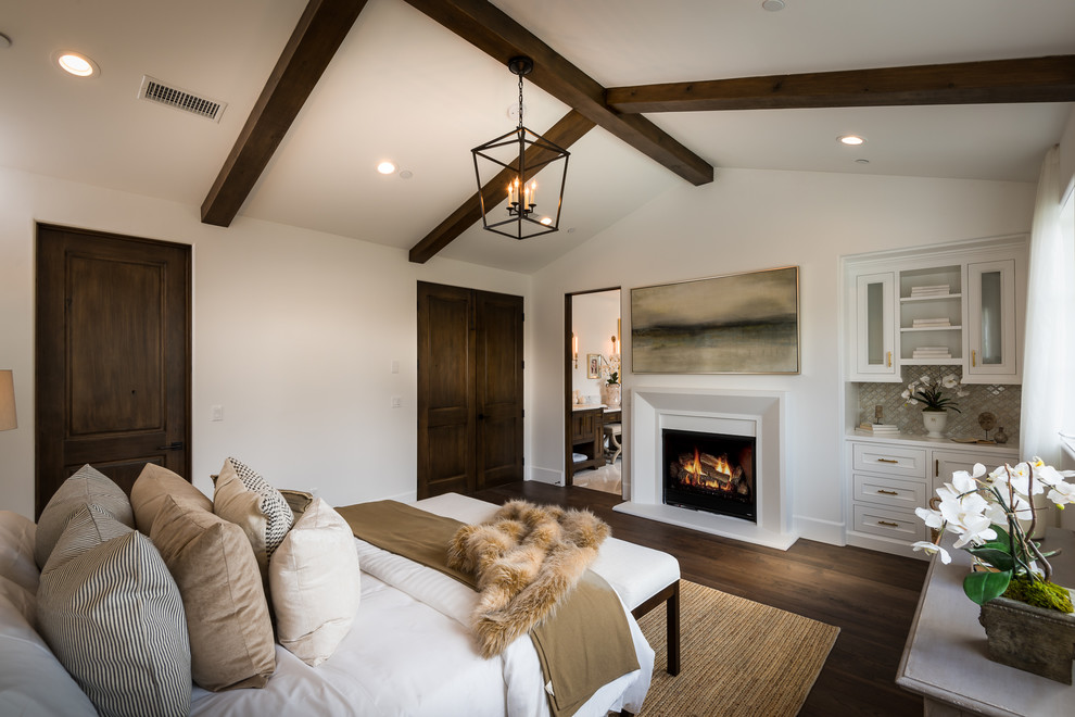 Inspiration for a traditional master and grey and brown bedroom in Los Angeles with white walls, dark hardwood flooring, a standard fireplace and brown floors.