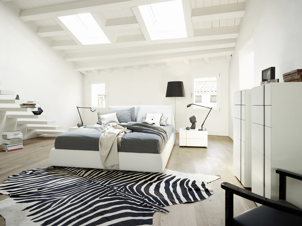 Réalisation d'une grande chambre minimaliste avec un mur blanc et parquet clair.