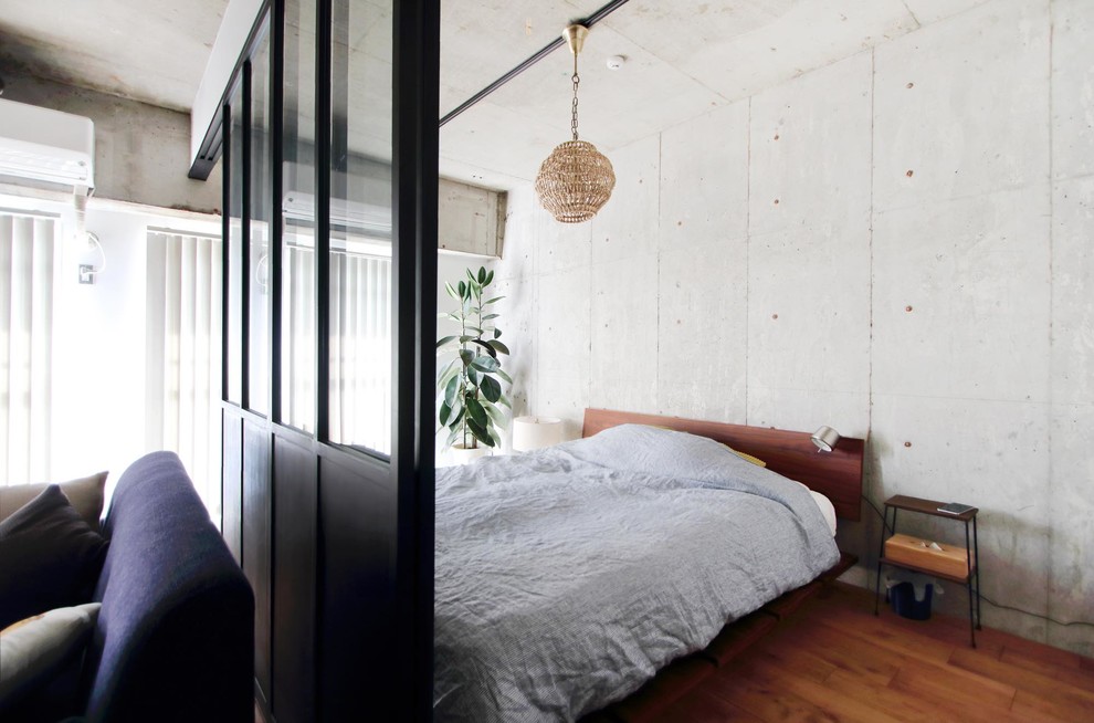 Идея дизайна: спальня в стиле лофт с серыми стенами, паркетным полом среднего тона и коричневым полом