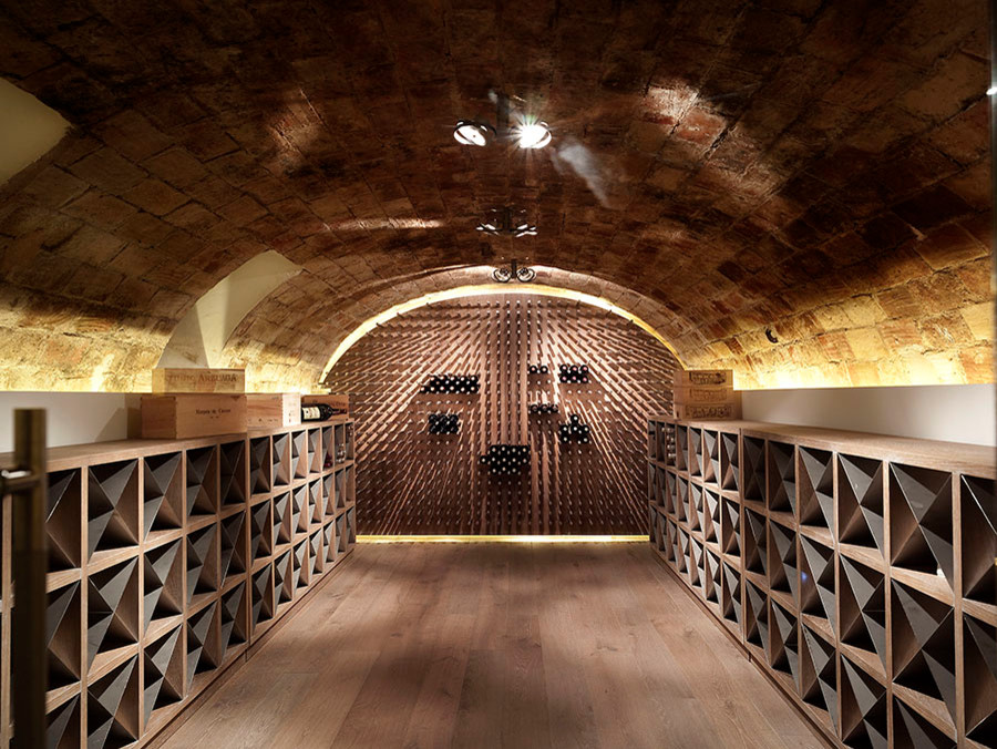 Large trendy medium tone wood floor wine cellar photo in Valencia with storage racks