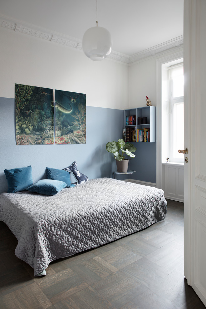Modelo de dormitorio infantil escandinavo con paredes azules, suelo de madera oscura y suelo marrón
