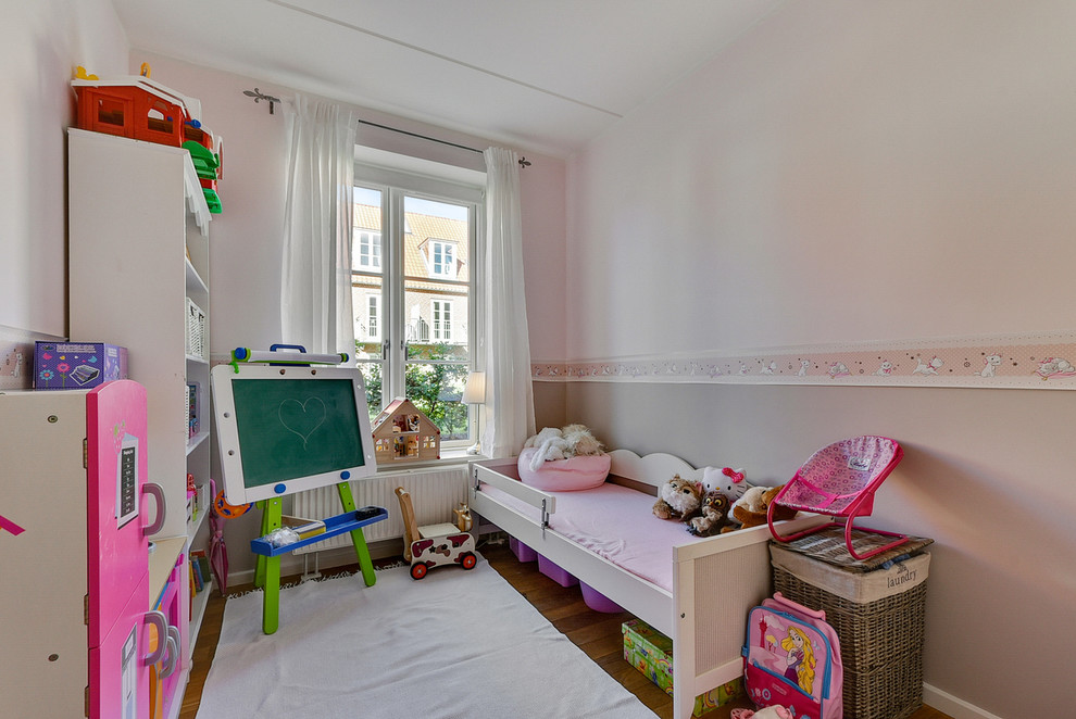 Inspiration for a mid-sized timeless girl light wood floor kids' room remodel in Copenhagen with pink walls