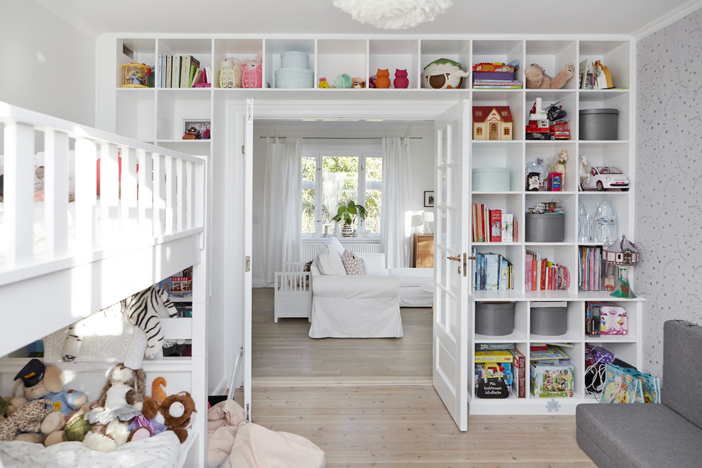На фото: детская среднего размера в скандинавском стиле с спальным местом, белыми стенами и светлым паркетным полом для ребенка от 4 до 10 лет, девочки с