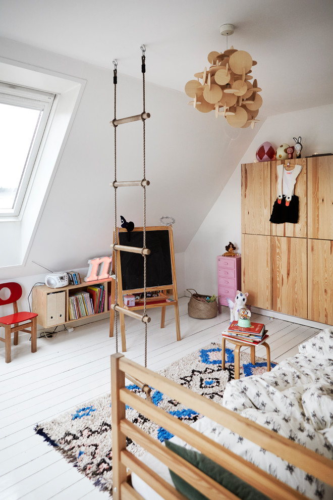 Inredning av ett skandinaviskt mellanstort könsneutralt barnrum kombinerat med lekrum och för 4-10-åringar, med vita väggar, målat trägolv och vitt golv