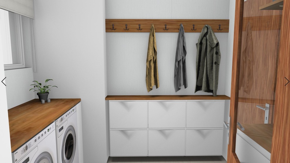 Photo of a small farmhouse utility room in Copenhagen with flat-panel cabinets, wood worktops, white walls, ceramic flooring, a side by side washer and dryer and beige floors.