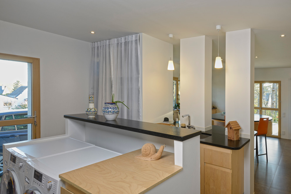 This is an example of a contemporary utility room in Angers with a submerged sink, granite worktops, white walls, ceramic flooring, beaded cabinets and a side by side washer and dryer.