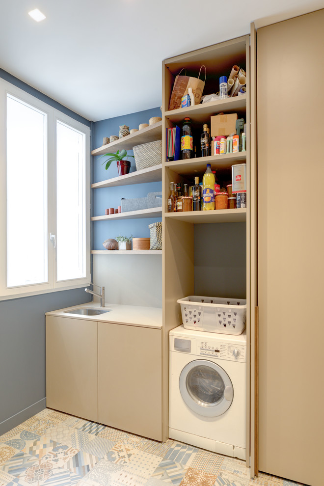 Imagen de lavadero multiusos y lineal actual de tamaño medio con fregadero bajoencimera, puertas de armario beige, paredes azules y suelo de baldosas de cerámica