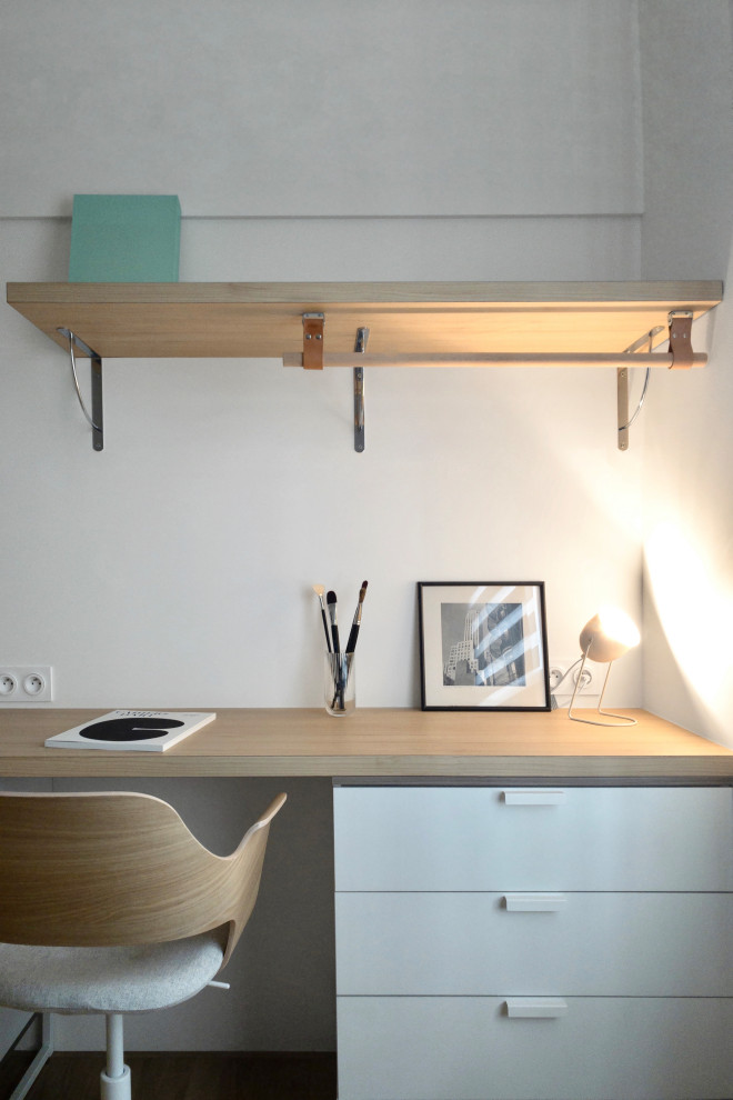 Imagen de despacho actual de tamaño medio con paredes blancas y suelo de madera en tonos medios