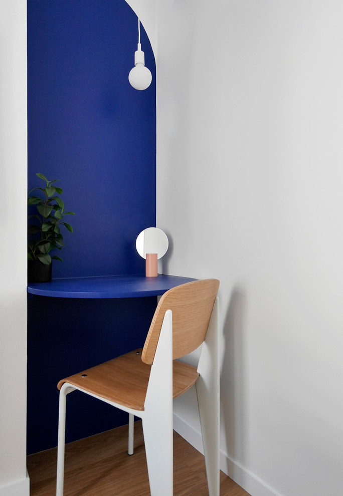 Kleines Modernes Arbeitszimmer mit Arbeitsplatz, blauer Wandfarbe, Vinylboden, Einbau-Schreibtisch und beigem Boden in Paris