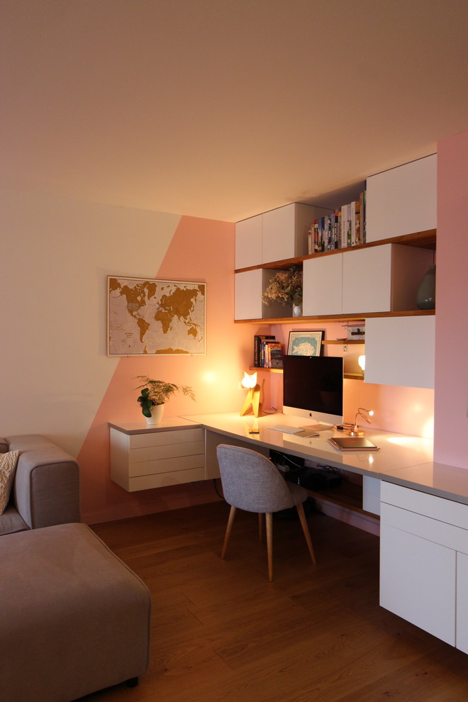 Small contemporary study in Marseille with pink walls, light hardwood flooring, a built-in desk, no fireplace and brown floors.