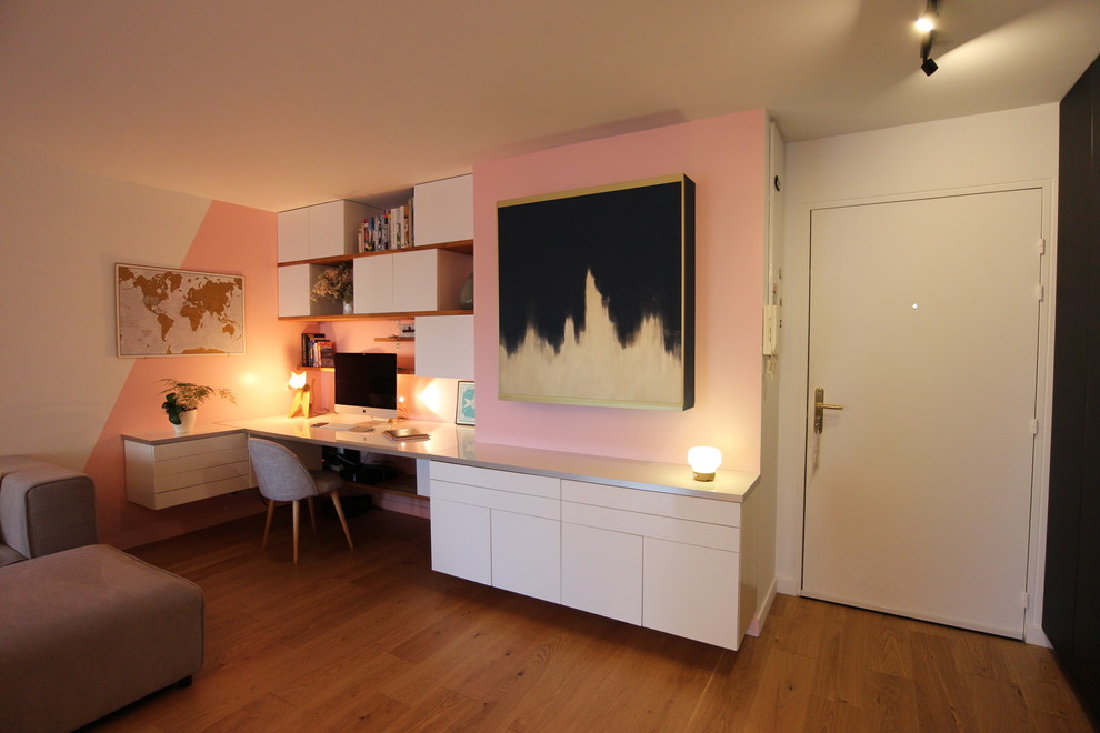 Imagen de despacho contemporáneo pequeño sin chimenea con paredes rosas, suelo de madera clara, escritorio empotrado y suelo marrón