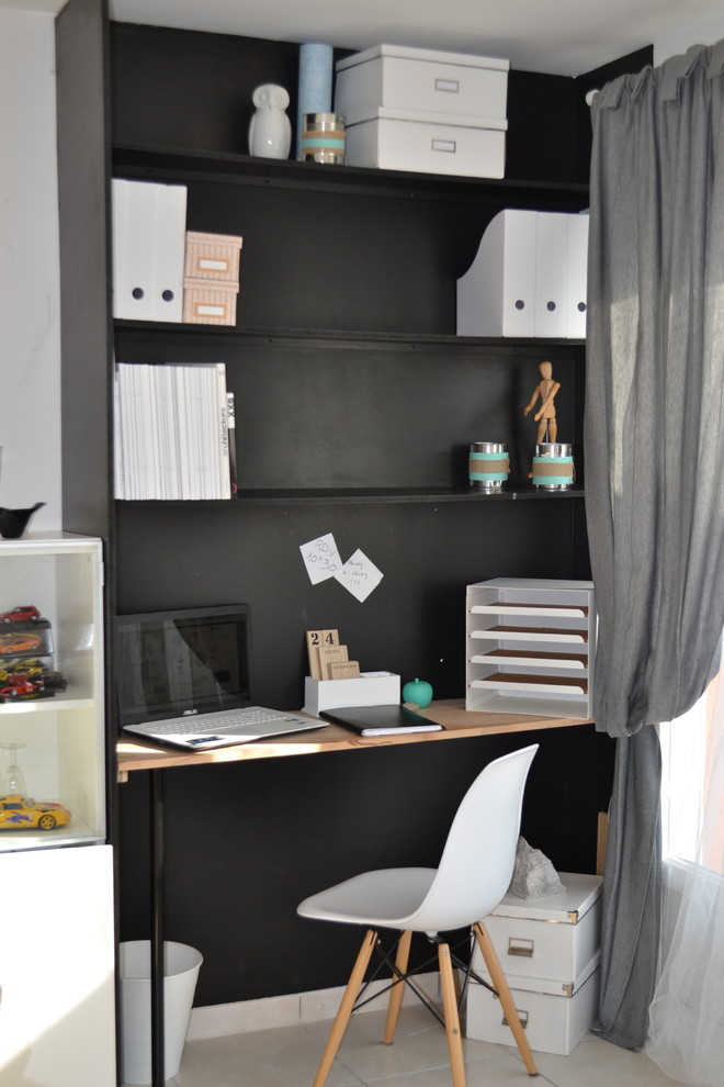 Small urban study in Other with black walls, a freestanding desk and white floors.
