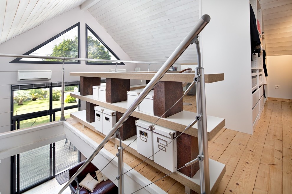Modelo de despacho contemporáneo de tamaño medio con paredes blancas, suelo de madera clara y suelo beige